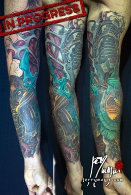 Undicesima seduta Tatuaggio biomeccanico a colori a tutta manica. Inserti metallici nella carne, tubi e artigli. Opera di Jerry Magni, miglior tatuatore, Bergamo, Milano, Lugano, provincia.