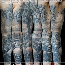 Black and grey full sleeve tattoo. A graveyard covered with skull from which rises a majestic olive tree. in the foreground there are a few tombstone. the artwork is completed by clouds at the horizon, above them a full moon on which there are clock arms pointing five minutes to midnight. Outstanding piece of art, masterfully done by by the best tattoo artist Jerry Magni, Bergamo, Milan, Lugano, Italy.