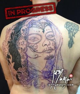 First sitting Black and grey Back piece tattoo. Portrait of a beautiful girl with the typical make up from the Mexican day of the dead, on her head a black lace veil, behind her a couple of roses, everything surrounded by filigree. Outstanding piece of art, masterfully done by by the best tattoo artist Jerry Magni, Bergamo, Milan, Lugano, Italy.