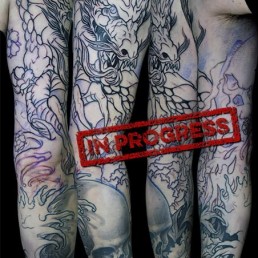 first sitting Black and grey Japanese style full sleeve tattoo with skulls, cherry flowers, waves and a big dragon that takes half of the sleeve. done by the best tattoo artist Jerry Magni, Bergamo, Milan, Lugano, Italy.