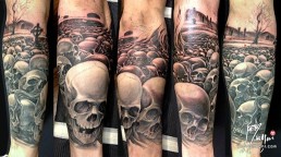 Third sitting Black and grey full sleeve tattoo. A graveyard covered with skull from which rises a majestic olive tree. in the foreground there are a few tombstone. the artwork is completed by clouds at the horizon, above them a full moon on which there are clock arms pointing five minutes to midnight. Outstanding piece of art, masterfully done by by the best tattoo artist Jerry Magni, Bergamo, Milan, Lugano, Italy.