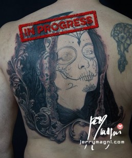 Third sitting Black and grey Back piece tattoo. Portrait of a beautiful girl with the typical make up from the Mexican day of the dead, on her head a black lace veil, behind her a couple of roses, everything surrounded by filigree. Outstanding piece of art, masterfully done by by the best tattoo artist Jerry Magni, Bergamo, Milan, Lugano, Italy.