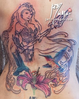 quarta seduta per Copertura vecchio tatuaggio e sviluppo nuovo tatuaggio a tutta schiena con Anfitrite, dea della mitologia greca, che emerge dalle acque. Indossa un’armatura sexy, ha capelli fluenti che circondano l’immagine in cui vediamo anche tue colibrì che volano su un giglio rosa. Dietro alla dea una decorazione ispirata alle opere di Mucha. Realizzato da Jerry Magni, miglior tatuatore, Bergamo, Milano, Brescia, Piacenza, Lecco, Como, Italia, Lombardia, provincia, Lugano.