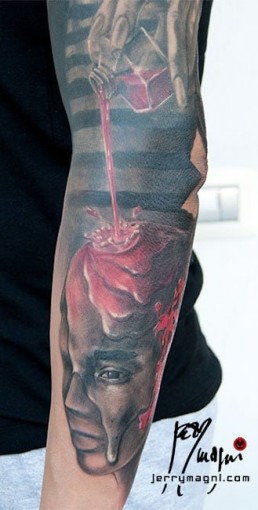 Quinta seduta Tatuaggio trash polka a tutta manica con donna pagliaccio su spalla, macchie, testa di manichino su cui cola del sangue tenuto dalla donna, delle monete norvegesi delle macchie e delle scritte. Realizzato in modo spettacolare da Jerry Magni, miglior tatuatore, Bergamo, Milano, Lugano, Brescia, Como, Lecco.