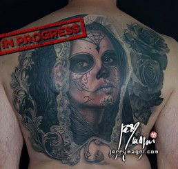 Sixth sitting Black and grey Back piece tattoo. Portrait of a beautiful girl with the typical make up from the Mexican day of the dead, on her head a black lace veil, behind her a couple of roses, everything surrounded by filigree. Outstanding piece of art, masterfully done by by the best tattoo artist Jerry Magni, Bergamo, Milan, Lugano, Italy.