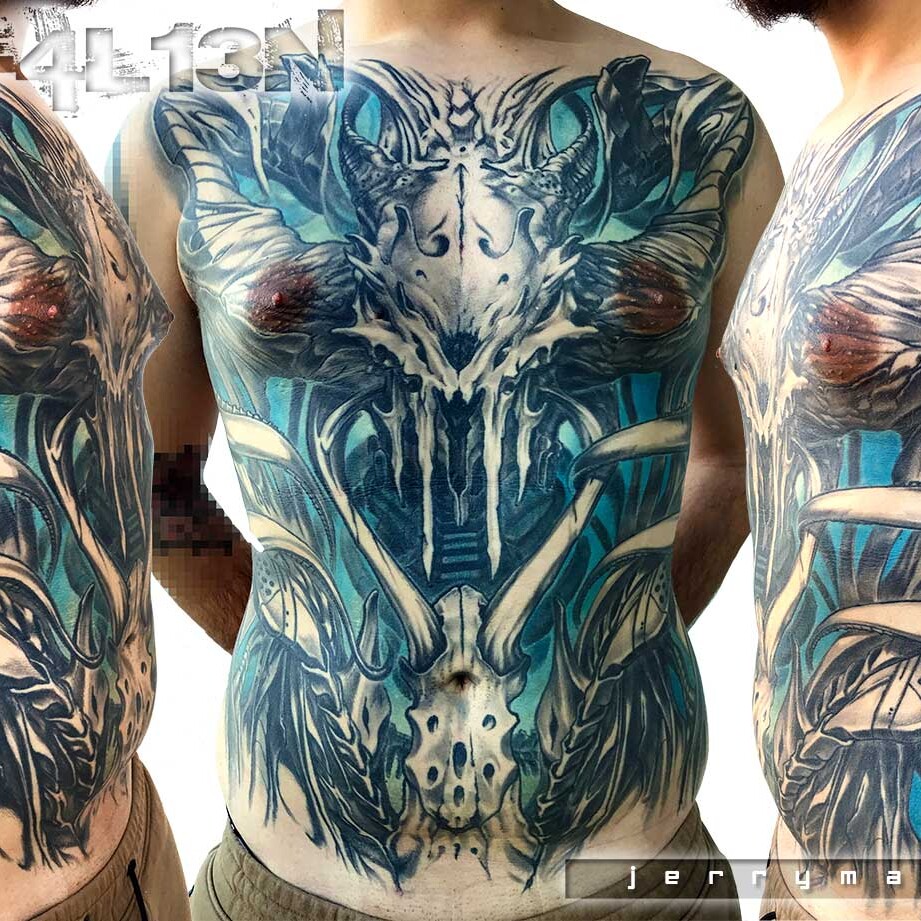Tatuaggio biomeccanico in bianco e nero e azzurro con teschio alieno al centro. Realizzato da Jerry Magni, miglior tatuatore italiano, Lobardia, Bergamo, Como, Lecco, Crema, Cremona, Varese, Milano