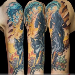 Unique tattoo of a wolf with a paw becoming a tree and the tail becoming a wave of water. In the background a sunset where, between the clouds we see a few arrows. Beautifully done by Jerry Magni, Best tattoo artis, Milan, Bergamo, Brescia, Lugano, Lombardy, Italy