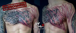 Seconda seduta Tatuaggio biomeccanico con strappi nella pelle da cui vediamo dei tubi fuoriuscire dalla carne, sviluppato su torace e braccio, realizzato a mano libera da Jerry Magni, miglior tatuatore, Bergamo, Milano, Lugano, Brescia, Como, Lecco
