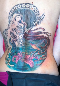settima seduta Copertura vecchio tatuaggio e sviluppo nuovo tatuaggio a tutta schiena con Anfitrite, dea della mitologia greca, che emerge dalle acque. Indossa un’armatura sexy, ha capelli fluenti che circondano l’immagine in cui vediamo anche tue colibrì che volano su un giglio rosa. Dietro alla dea una decorazione ispirata alle opere di Mucha. Realizzato da Jerry Magni, miglior tatuatore, Bergamo, Milano, Brescia, Piacenza, Lecco, Como, Italia, Lombardia, provincia, Lugano.