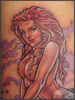 Detail from Full colour tattoo with a sexy blue tail mermaid on a rock, in front of her a blue winged dragon rises from the water, Under the sea surface we see corals. Masterfully executed by the best tattoo artist Jerry Magni, Bergamo, Italy, Milano, Italy, Lugano.
