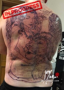 prima seduta tatuaggio realistico su schiena con ragazza nuda che abbraccia un leone, sullo sfondo una cascata e della vegetazione. eseguito da Jerry Magni miglior tatuatore Bergamo, Milano, Brescia, Varese, Lecco, Como, Mantova, Crema, Cremona, Vicenza, Verona, Nord Italia.