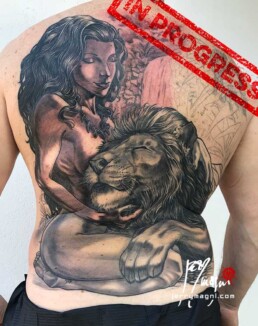 quinta seduta tatuaggio realistico su schiena con ragazza nuda che abbraccia un leone, sullo sfondo una cascata e della vegetazione. eseguito da Jerry Magni miglior tatuatore Bergamo, Milano, Brescia, Varese, Lecco, Como, Mantova, Crema, Cremona, Vicenza, Verona, Nord Italia.